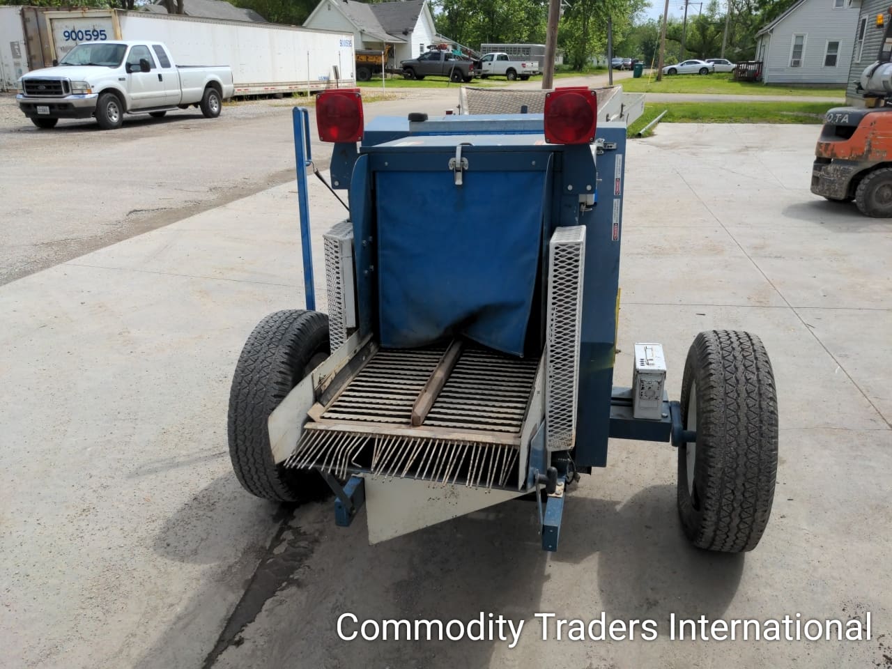 A blue trailer with a brush on the back.