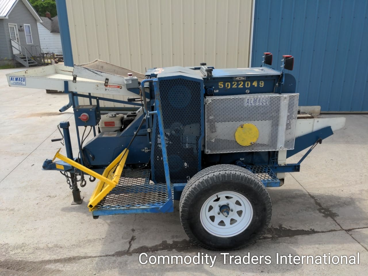 A blue and white trailer with a yellow tractor on it