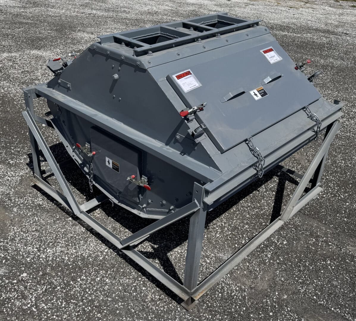 A large gray metal box sitting on top of a cement ground.