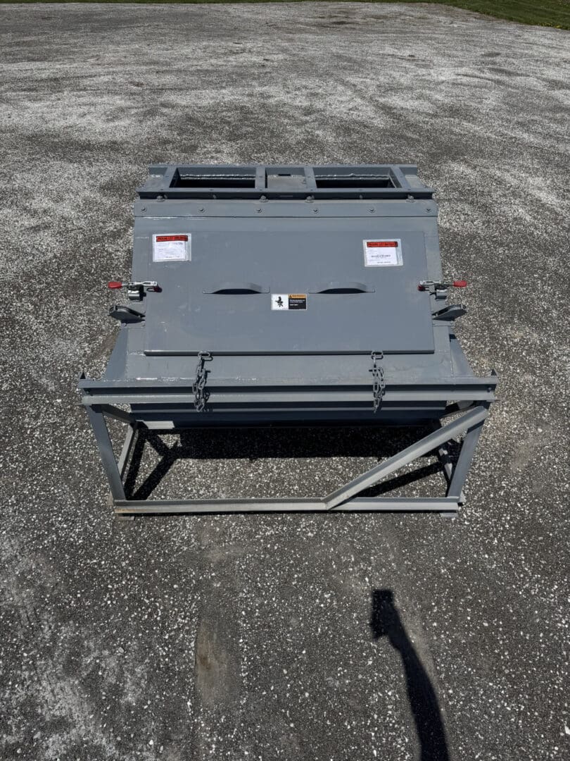A gray box sitting on top of concrete.