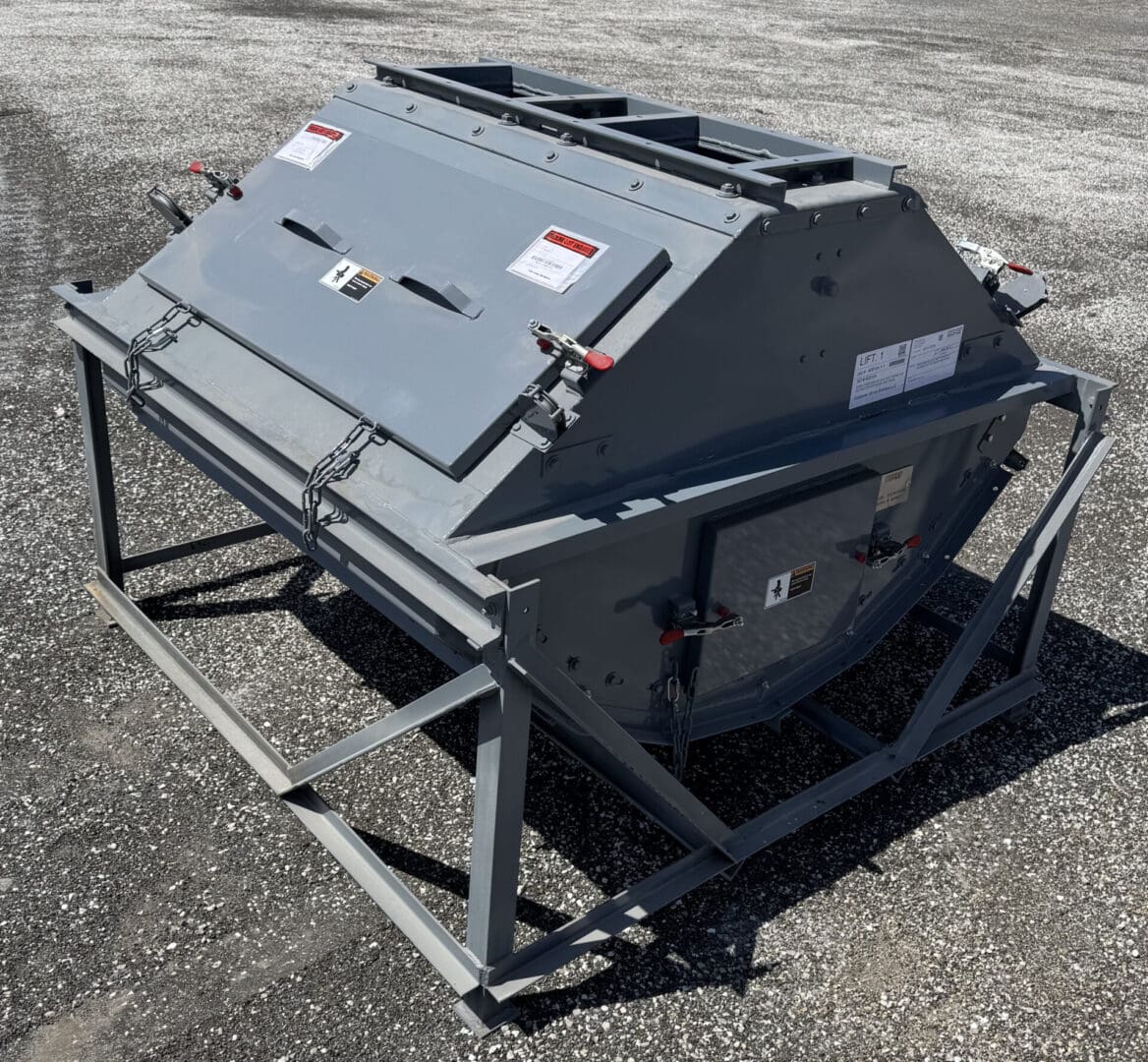 A large gray metal box sitting on top of a cement ground.