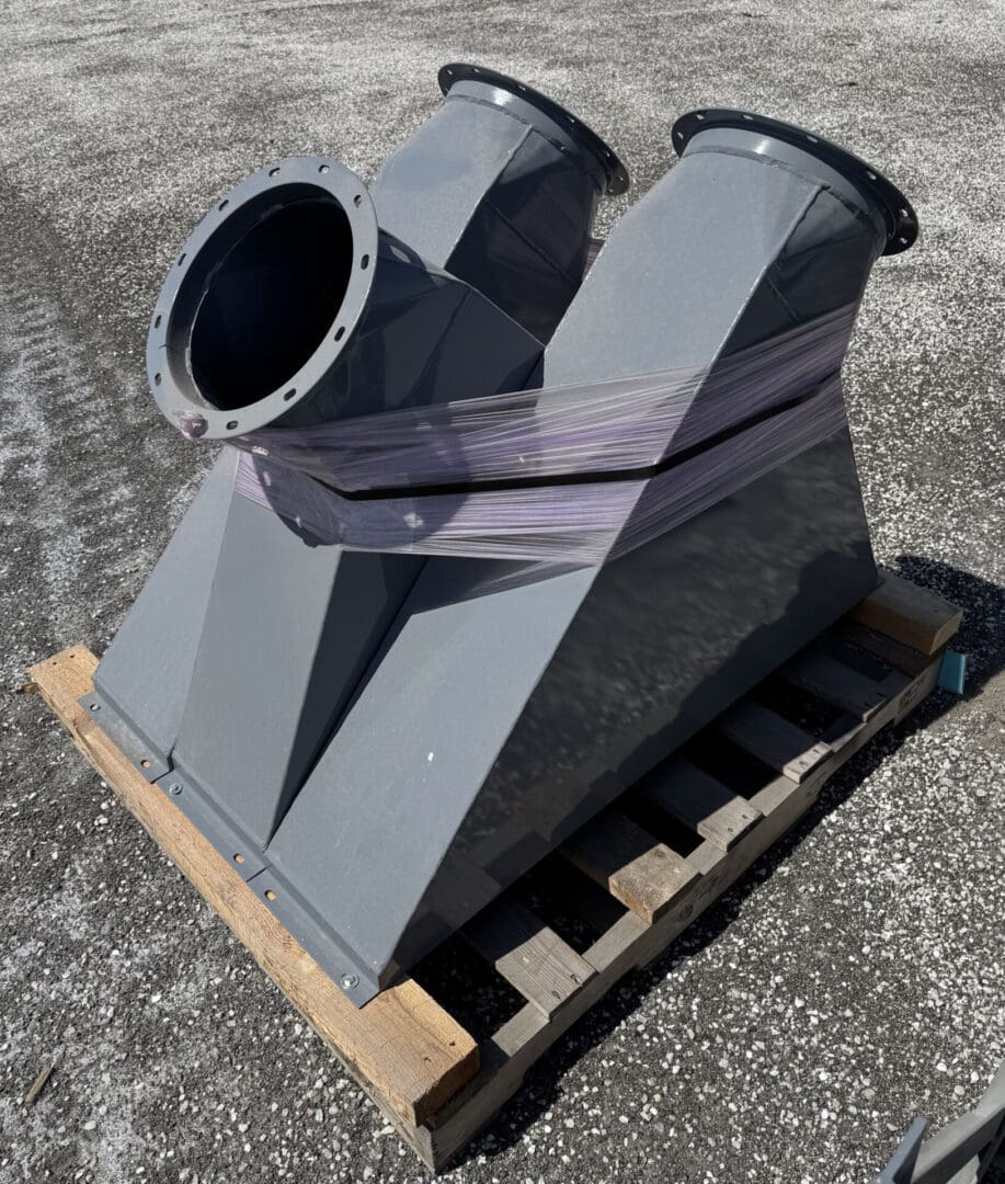 A gray metal object sitting on top of a wooden pallet.
