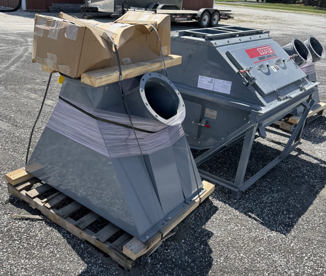A large gray metal object sitting on top of pallets.