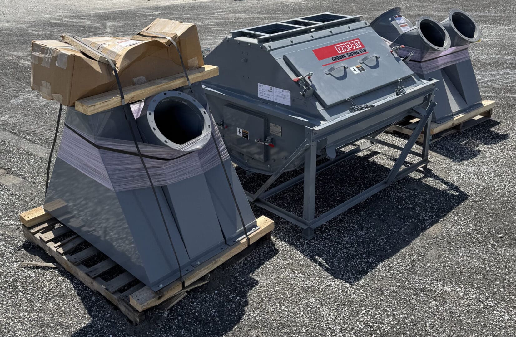 A couple of large gray pieces of equipment on top of a wooden pallet.
