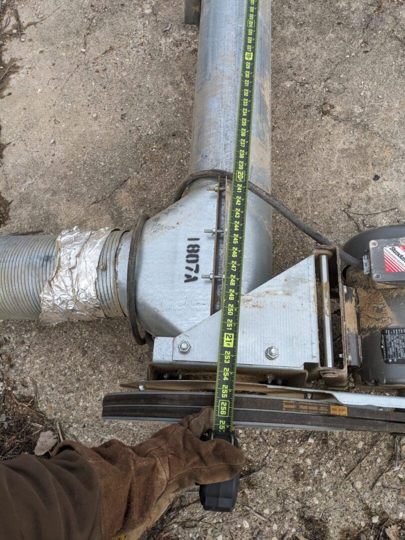 A pipe laying on the ground with a tape measure around it.
