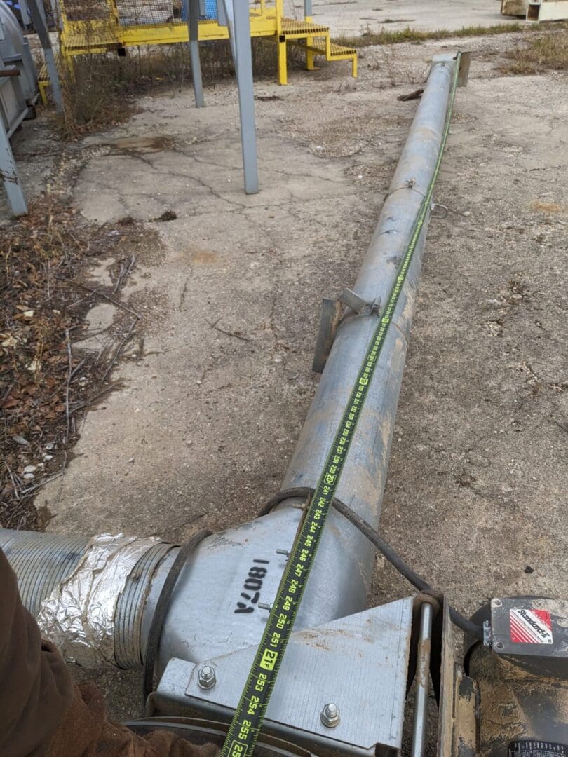A pipe with a tape measure attached to it.