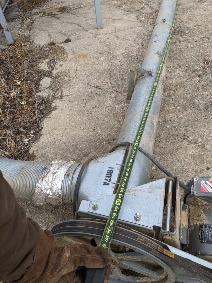 A pipe laying on the ground with a tape measure around it.