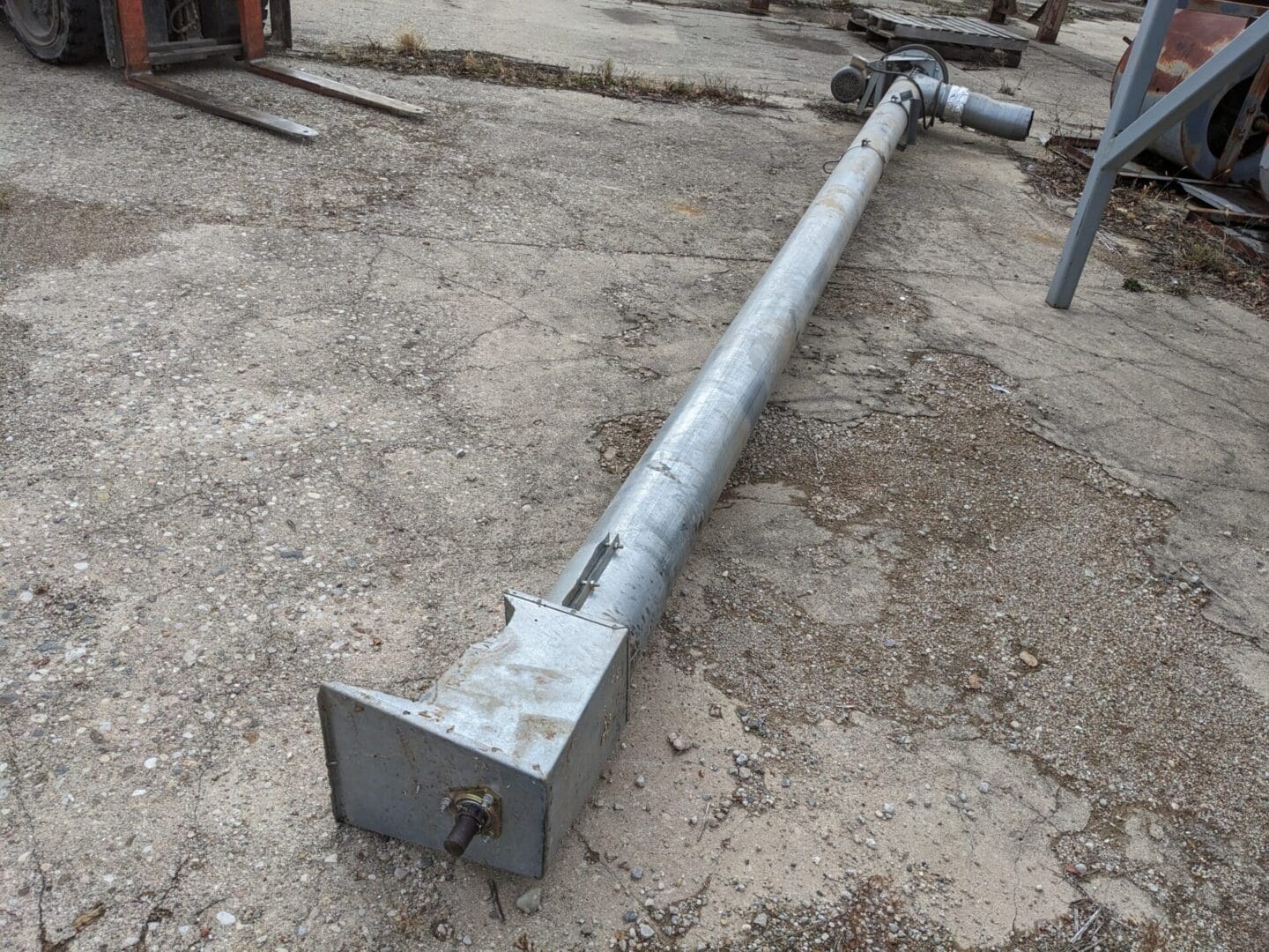 A metal pole sitting on top of concrete.