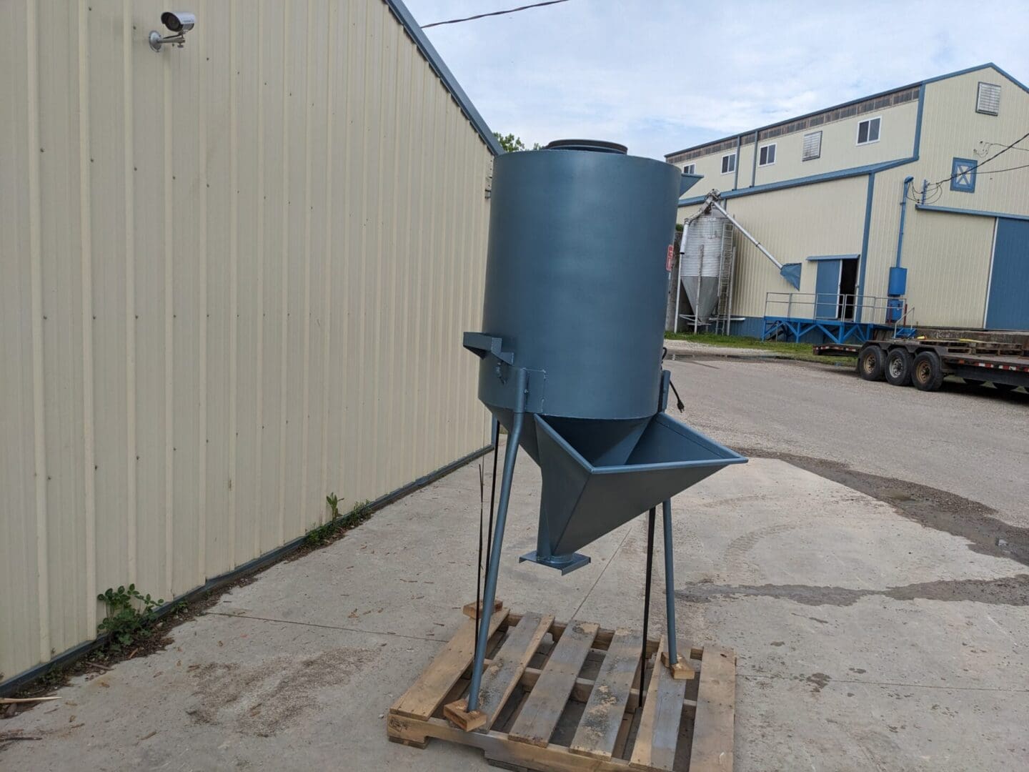 A blue bucket sitting on top of a wooden pallet.