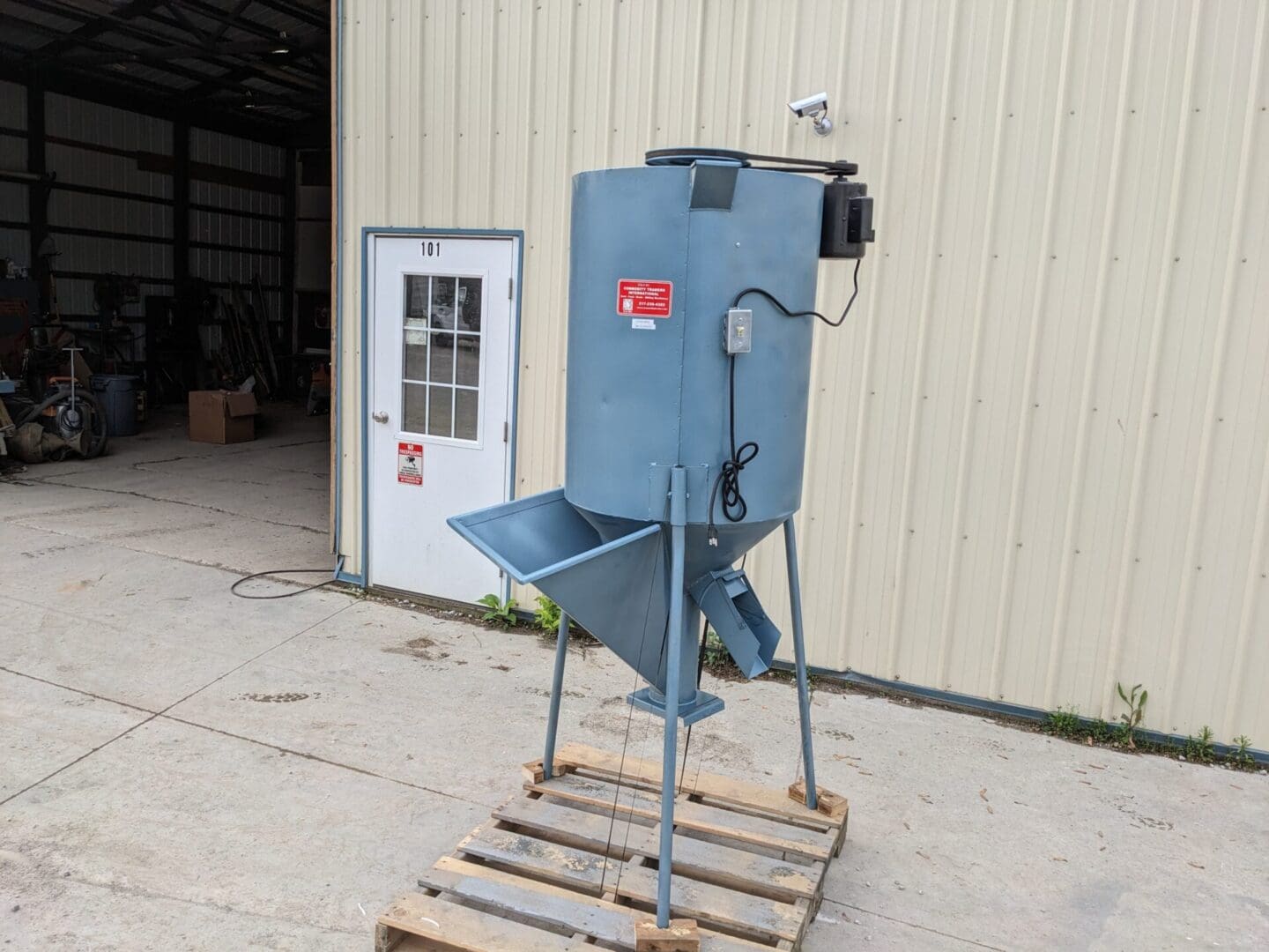 A blue machine sitting on top of pallets.