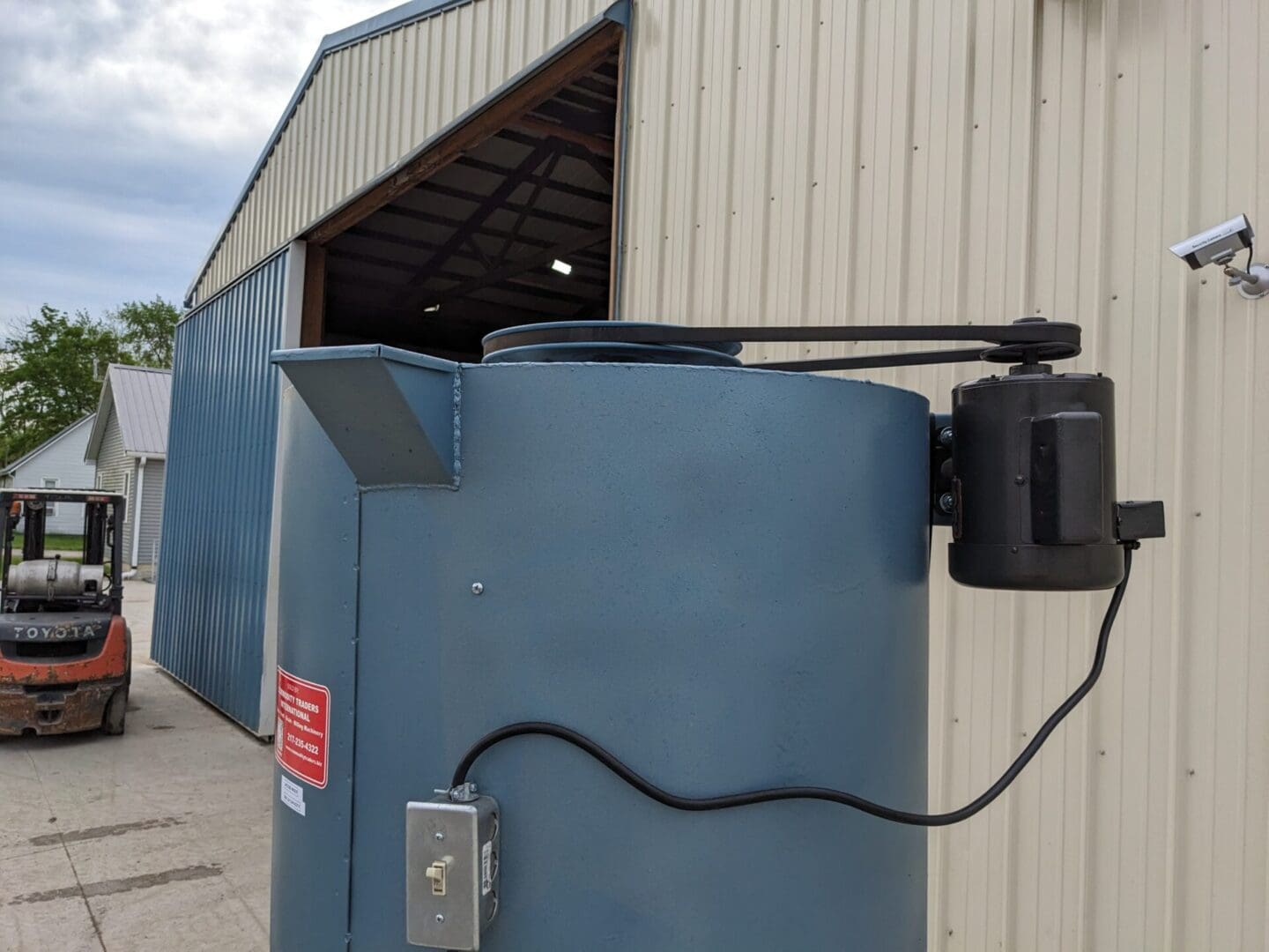 A blue electric meter sitting next to a building.