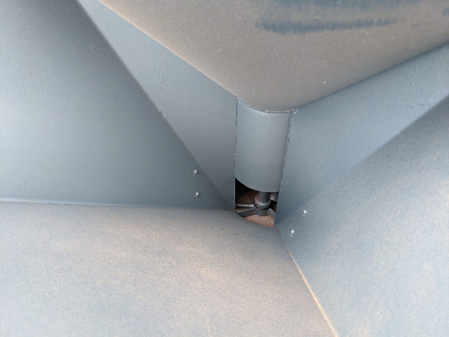 A cat is sitting inside of a pipe.