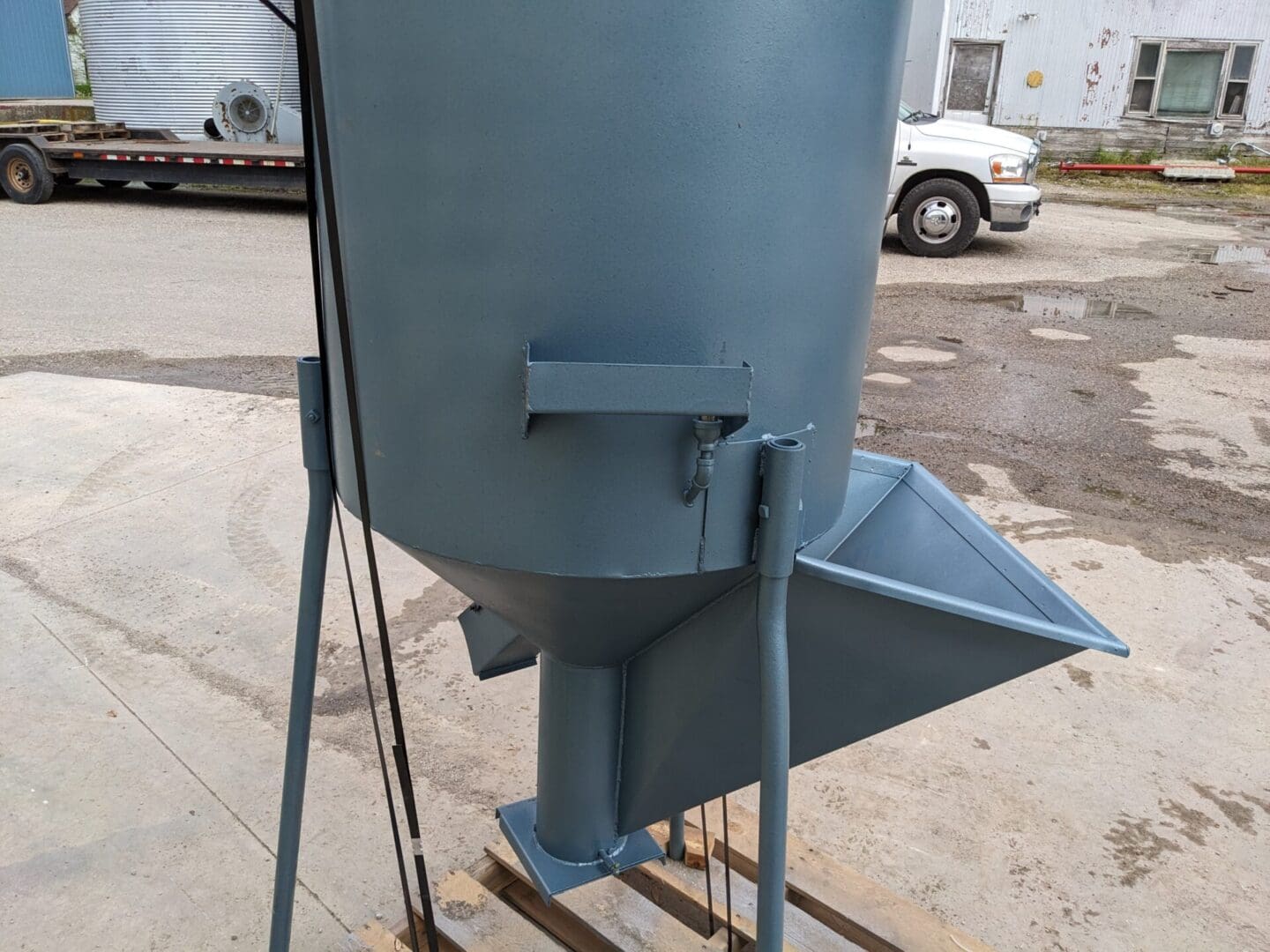 A large metal bin sitting on top of concrete.
