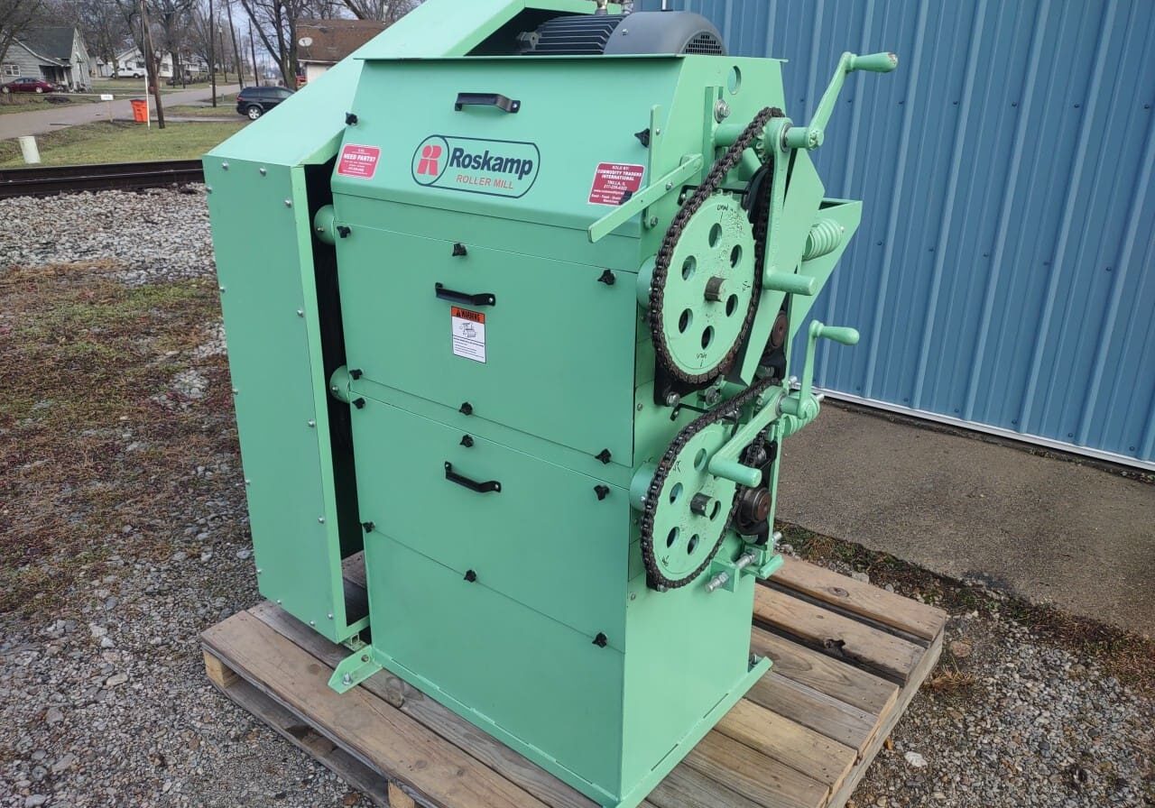 A green machine sitting on top of a wooden pallet.