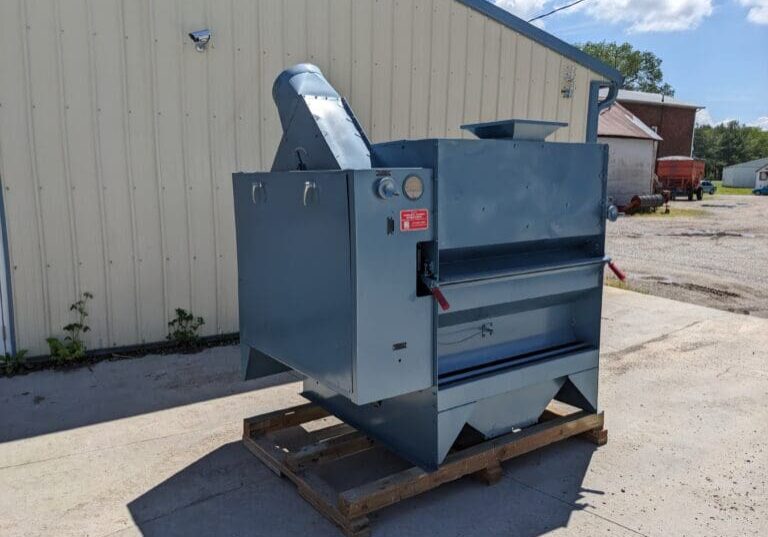 A large metal machine sitting on top of a wooden pallet.