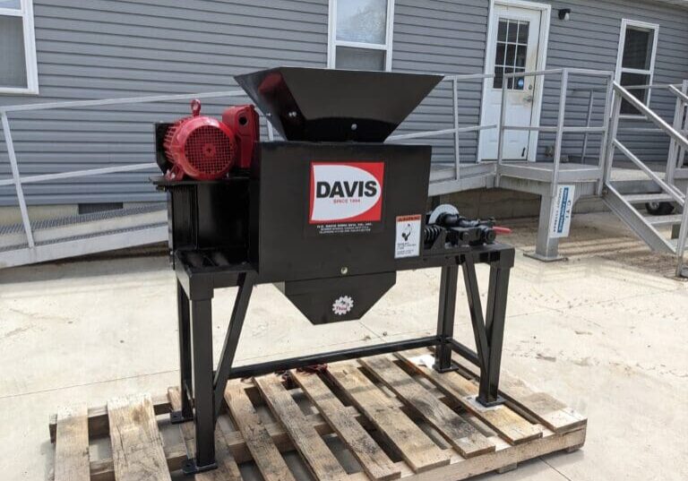 A black machine sitting on top of a wooden pallet.