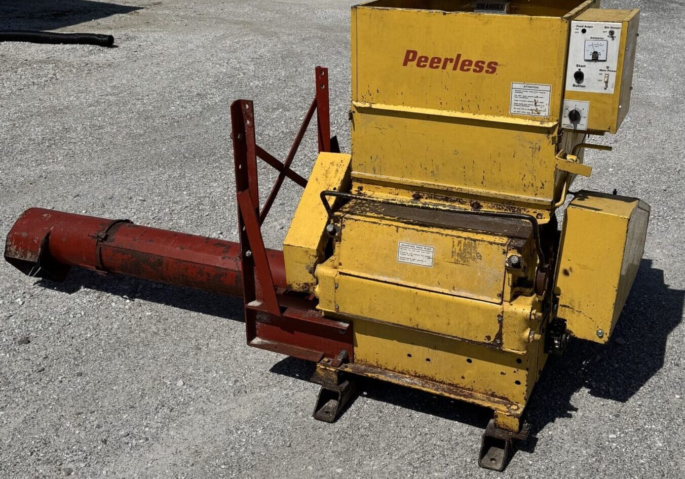 A yellow machine sitting on the ground next to a red pole.